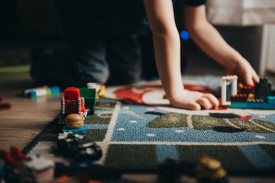 Midsection of boy playing with toys at home