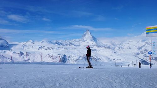 Man skiing on snowcapped mountain against sky