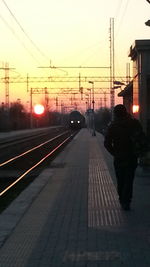 Railroad station against sky during sunset