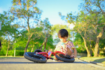 Side view of boy sitting on car