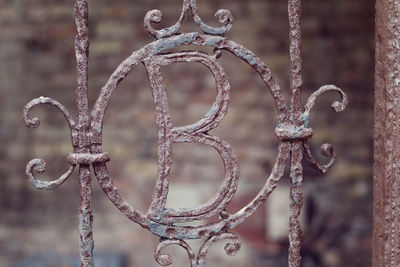 View of rusty gate with letter b