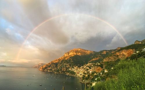 Scenic view of rainbow over sea against sky