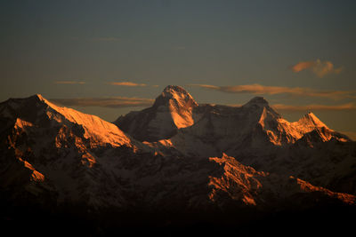 Aerial view of snowcapped mountains against sky during sunset