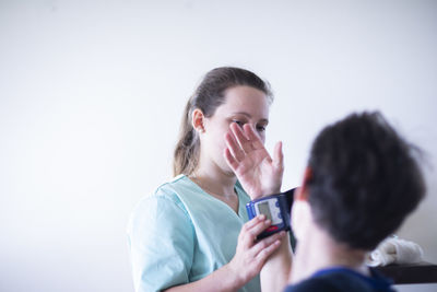 Nurse tigthing a blood pressure meters to a patient female