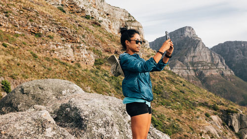 Smiling woman photographing landscape