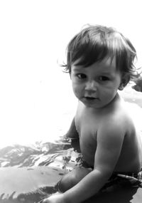 Portrait of cute baby boy sitting in lake