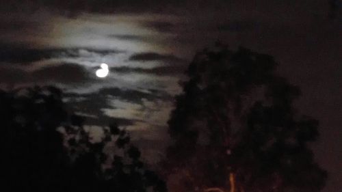 Low angle view of moon against cloudy sky