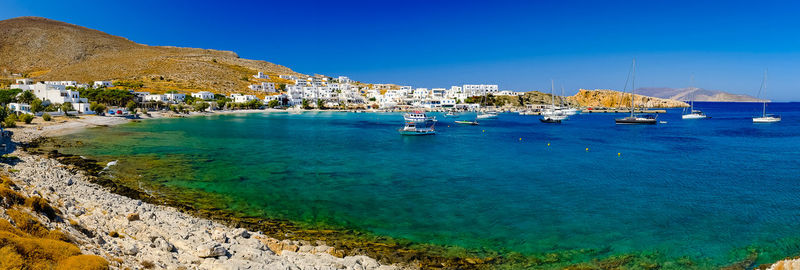 Scenic view of sea by buildings against blue sky