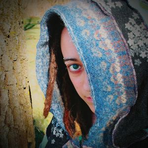 Close-up portrait of woman with dreadlocks wearing hood