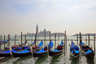 Gondolas moored at pier with church of san giorgio maggiore in background