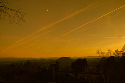 Scenic view of silhouette landscape against orange sky