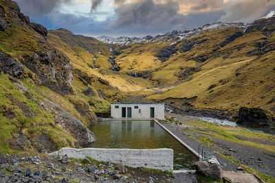 Scenic seljavallalaug geothermal hotspring pool against mountains during sunset