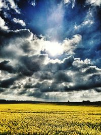 Scenic view of field against cloudy sky