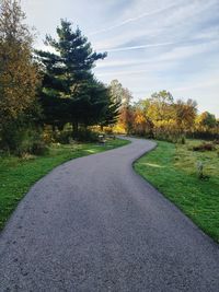 Road amidst trees against sky