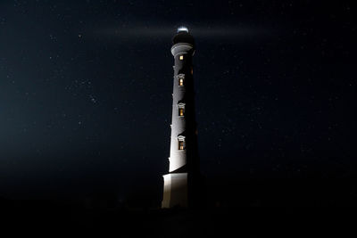 Low angle view of illuminated tower against sky at night