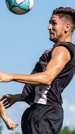 Low angle view of man playing against blue sky