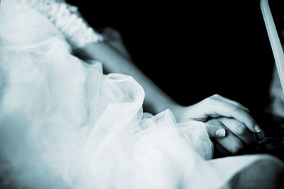 Midsection of bride and bridegroom holding hands