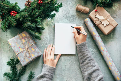 High angle view of woman with christmas tree on table