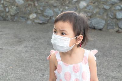 Girl wearing mask looking away outdoors