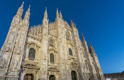 Low angle view of historical building against clear blue sky