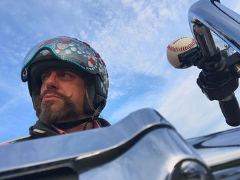 Low angle view of man sitting on motorcycle against sky