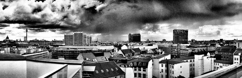 Buildings in city against cloudy sky