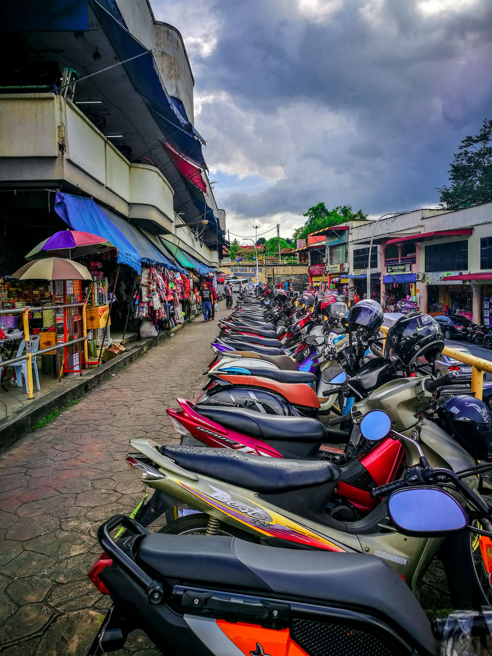 BICYCLES PARKED ON STREET IN CITY AGAINST SKY