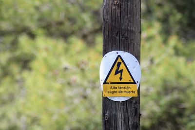 Close-up of sign on wooden post