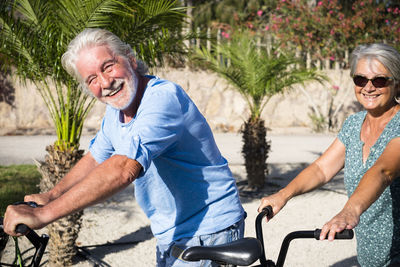 Portrait of smiling senior couple riding bicycle
