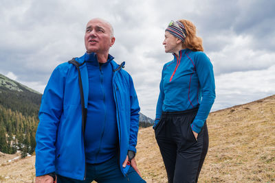 Rear view of couple standing against sky