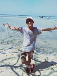 Portrait of smiling young woman standing on beach