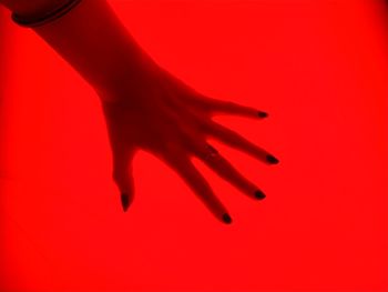 Low section of woman against red background