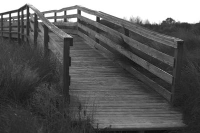 Wooden footbridge against clear sky