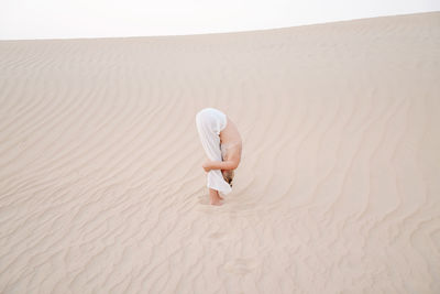 Woman in the desert doing forward fold