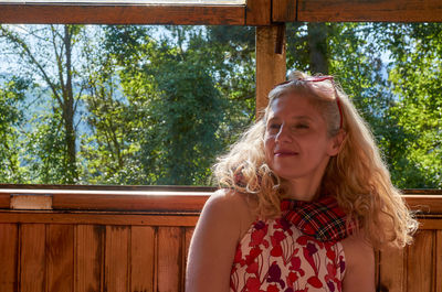 Portrait of smiling woman against trees