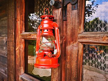 Close-up of red lantern hanging on wood outside temple