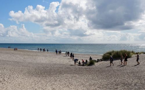 People on beach against sky