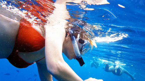 Low section of man swimming in sea