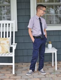 Full length of young man standing against brick wall