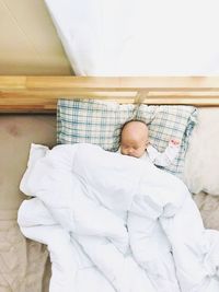 High angle view of man sleeping on bed