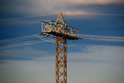 Low angle view of electricity pylon against sky