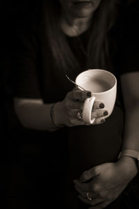 Midsection of woman holding coffee cup