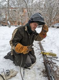 Side view of man working on snow
