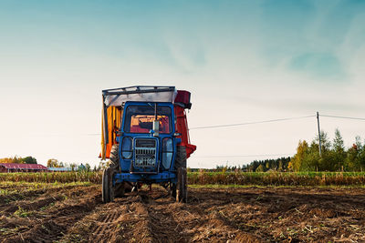 Tractor on agricultural field against sky