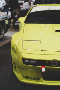 Close-up of yellow car on road