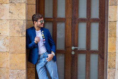 Full length of young man standing against wall