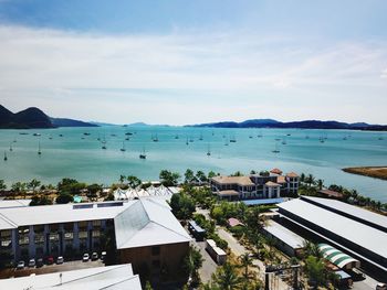 High angle view of houses by sea against sky