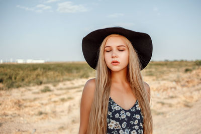 Teenage girl wearing hat against sky
