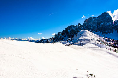 Scenic view of snowcapped mountains against blue sky