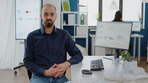 Portrait of young man standing in office